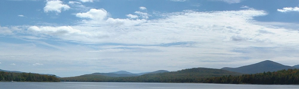 Overcast blue sky with mountain range in the distance.